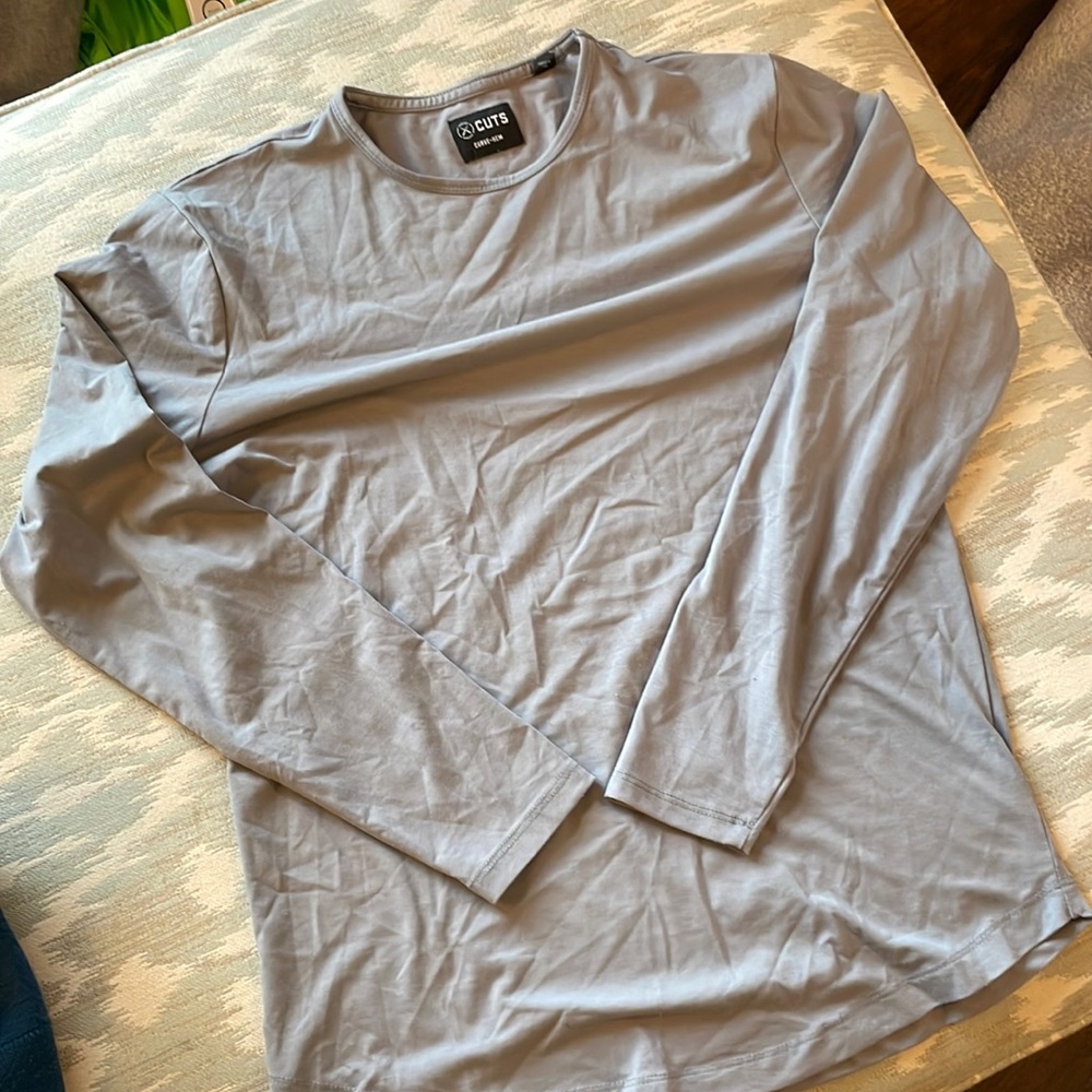 Cuts long sleeve curved hem T-shirt in a grey blue color